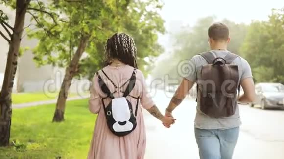 年轻夫妇孕妇和男人牵着手在城市里散步亲吻视频的预览图
