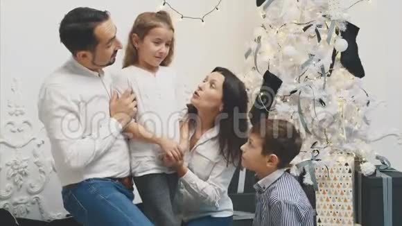 母亲父亲和弟弟贝加姆在白色的圣诞节背景下哭泣的小女儿视频的预览图