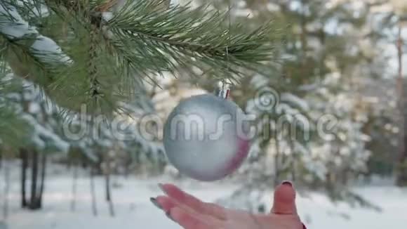 冬季森林中旋转闪亮圣诞球的近景视频的预览图