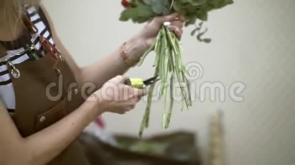 花店的女孩用子在花束中加工花茎的末端视频的预览图