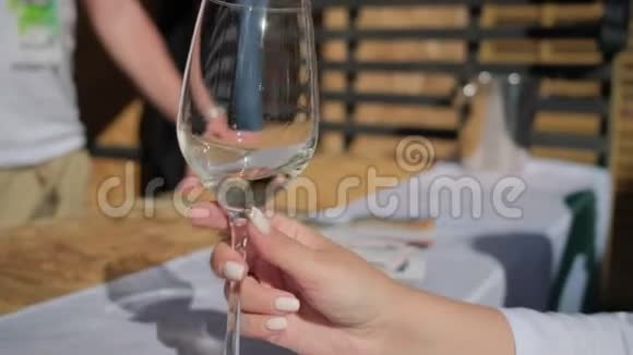 女士的手在高杯中摇着白葡萄酒视频的预览图
