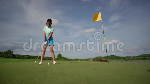 漂亮的女孩穿着蓝色短裤打高尔夫球在阳光明媚的日子里打高尔夫球训练得很好视频的预览图