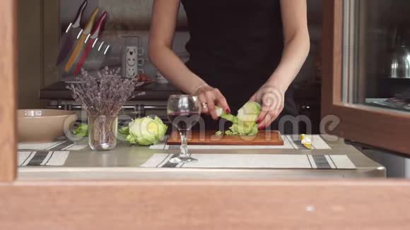 年轻女性在厨房做饭做午餐准备在木切板上做包皮生菜薰衣草一种视频的预览图