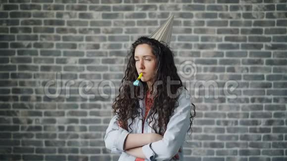 生日女孩戴着派对帽吹口哨独自站着的悲伤肖像视频的预览图