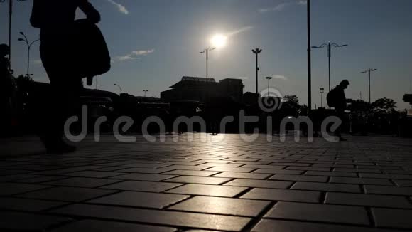 人们的剪影在阳光下沿着中心广场漫步视频的预览图