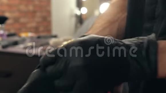 美容院男手戴黑色乳胶手套双手放在黑色手套的发型师身上用于理发视频的预览图
