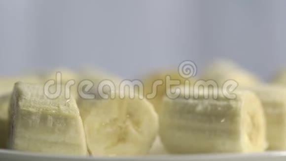 美味的成熟香蕉切片放在白色盘子里旋转视频的预览图