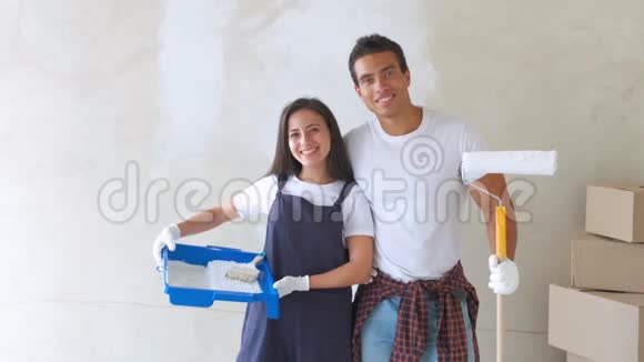 一对年轻夫妇在新房子里的画像正在粉刷和装饰他们房子的墙壁视频的预览图