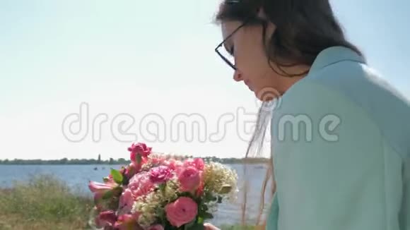 戴墨镜的快乐花店女收集大自然上美丽的粉红色花束视频的预览图