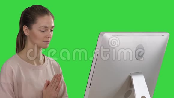 有魅力的女人坐在桌子上的椅子上电脑在绿色屏幕上冥想Chroma键视频的预览图