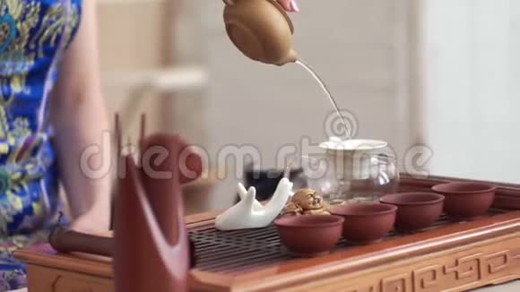 女孩小心翼翼地在小木桌上举行中国茶道视频的预览图
