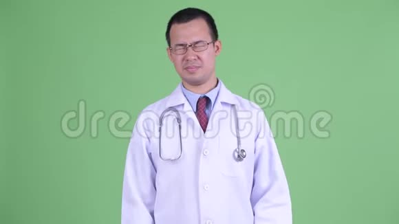 戴眼镜头痛的亚洲男医生视频的预览图