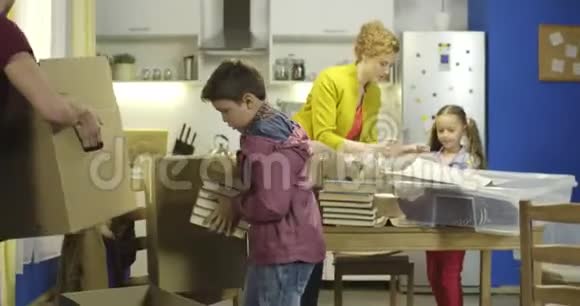 幸福的家庭在厨房里打开盒子视频的预览图