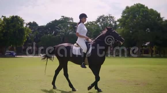 白天骑马的年轻骑手白天在露天竞技场上骑马的快乐女孩视频的预览图