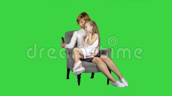小女孩和她的母亲在绿色屏幕上自拍Chroma键视频的预览图
