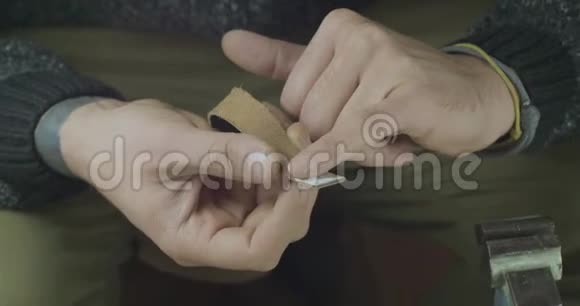 一种用手指将胶水涂在黑色皮革条上的皮革工匠手工制品皮革手工电影院4k视频视频的预览图