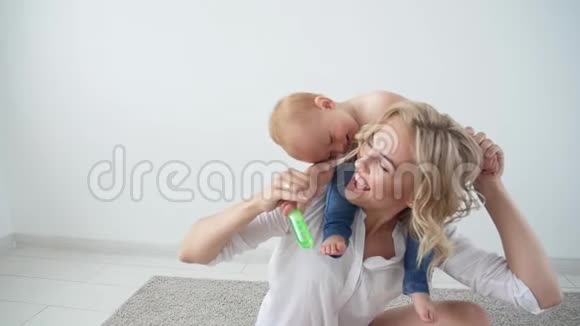 童年母亲和家庭的概念幸福的母亲把孩子抱在白色的背景上视频的预览图