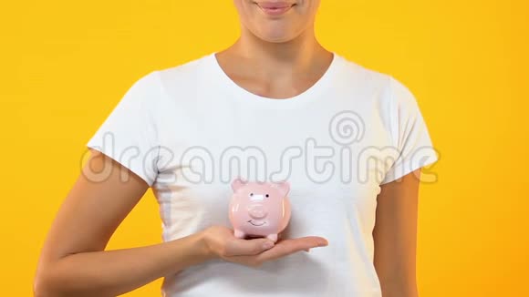 微笑女性持有储蓄罐家庭预算未来投资储蓄视频的预览图