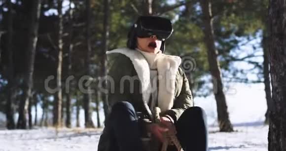 有魅力的女士非常印象深刻使用虚拟现实眼镜玩一个骑马游戏而坐在雪橇外面视频的预览图