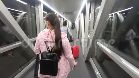 旅游女孩走在灯火通明的走廊上飞往机场视频的预览图
