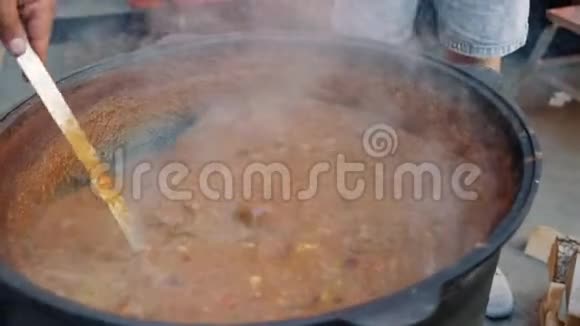 厨师用大锅搅拌汤汁视频的预览图