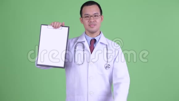 快乐的亚洲男子医生展示剪贴板并竖起大拇指视频的预览图