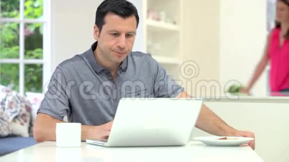 西班牙夫妇在吃早餐时看笔记本电脑视频的预览图