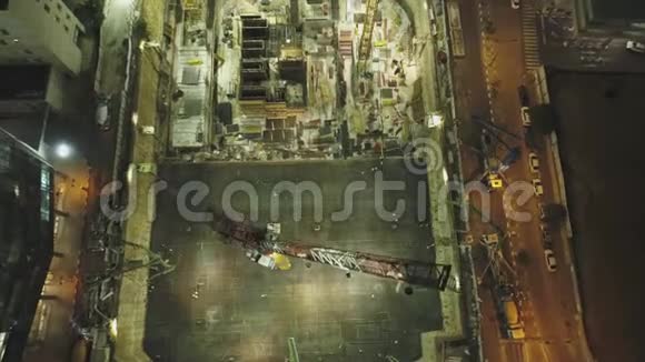 施工现场夜景空中无人机在巨大的建筑之上有起重机和重型机器有城市景观视频的预览图