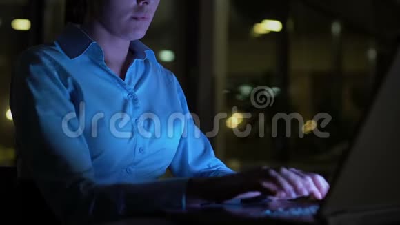 商务女性晚上在办公室打手提电脑用电脑屏幕照明视频的预览图