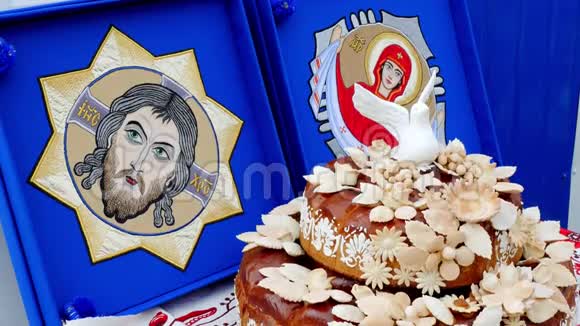 特写镜头很漂亮的面包一个大馅饼上的精美糕点装饰附近有基督和神母的偶像视频的预览图