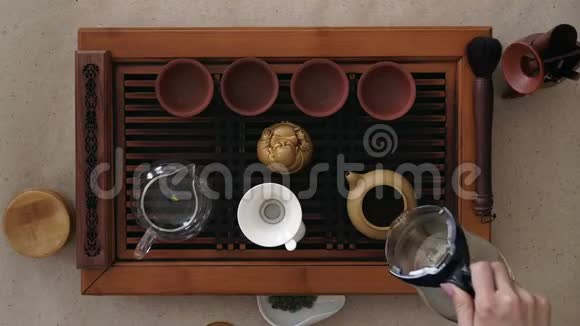 顶景茶具一个木桌用于茶道背景女孩把开水倒进茶壶里视频的预览图