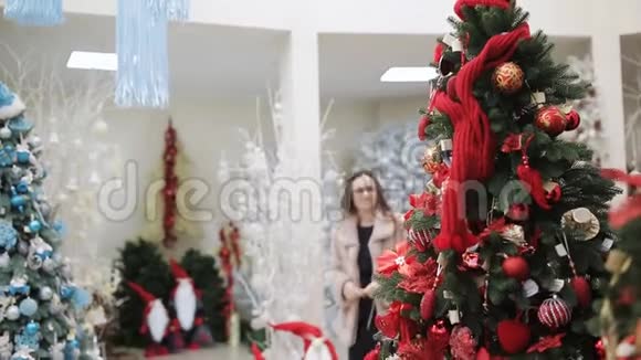 两位女士在圣诞前夜在一家购物中心选择圣诞装饰品来庆祝圣诞节视频的预览图