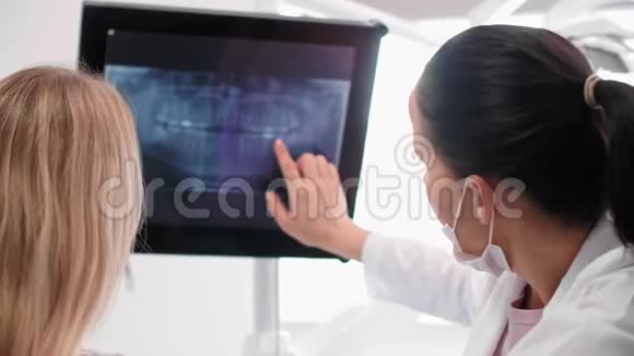 女牙医指着病人x光视频的预览图