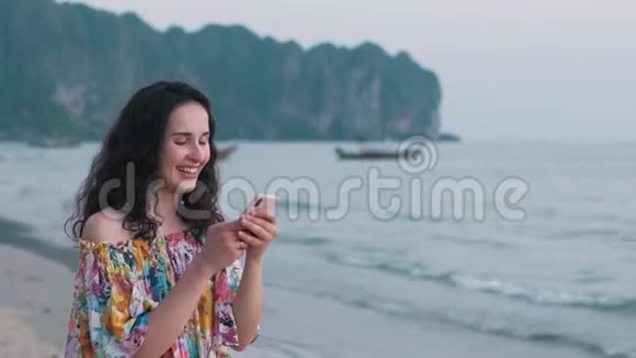 女孩在海洋附近使用智能手机视频的预览图