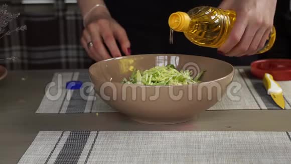 年轻女性在厨房做饭做午餐准备带葵花油的沙拉酱薰衣草视频的预览图