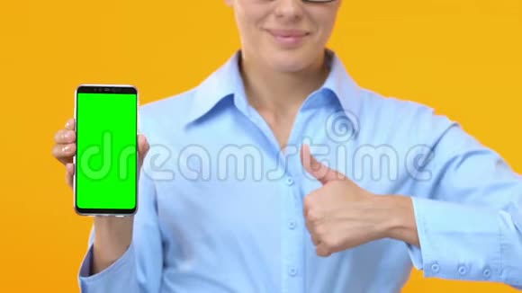 商务女士带绿色屏幕和拇指的智能手机在线服务视频的预览图