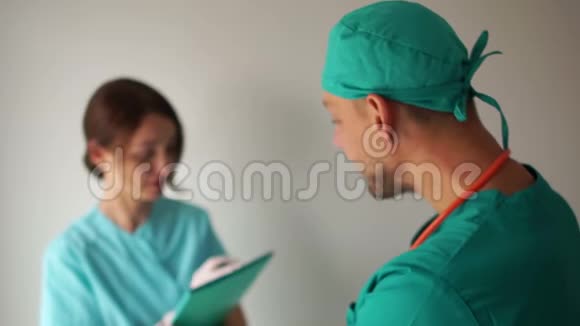 专注的护士在笔记本上写下治疗师指示旁路医务人员视频的预览图