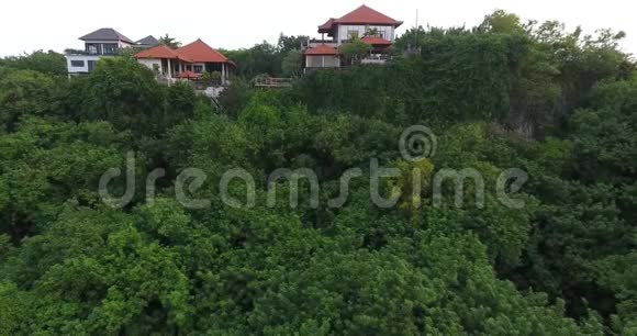 从高角度观看巴厘岛许多树木和房屋度假胜地4k视频的预览图