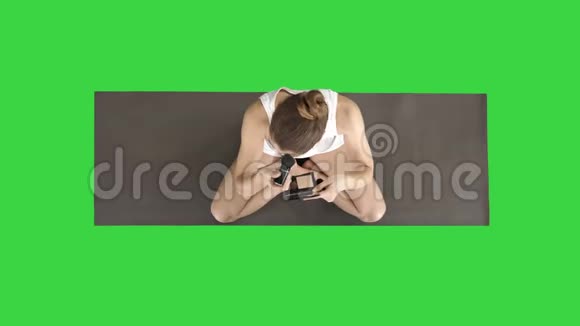 瑜伽女人在做化妆时坐在莲花姿势上的绿色屏幕铬键视频的预览图