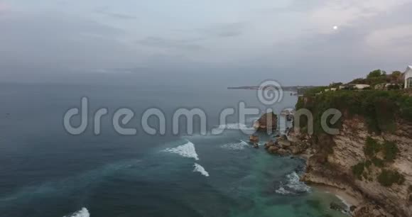 巴厘岛的岩石海岸线有巨大的悬崖和泡沫般的海浪4K视频的预览图