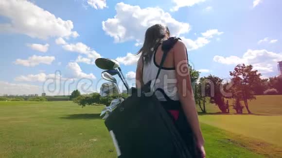 一位女士带着高尔夫配件行走的背面视频的预览图