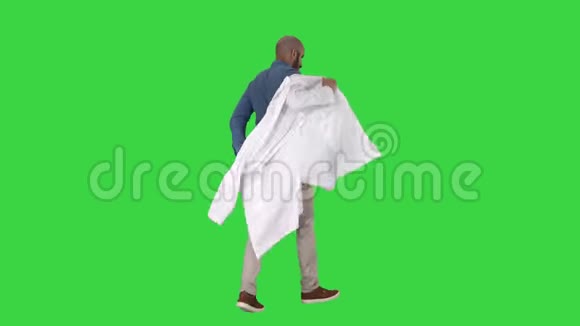 步行医生把白色长袍放在绿色屏幕上Chroma键视频的预览图