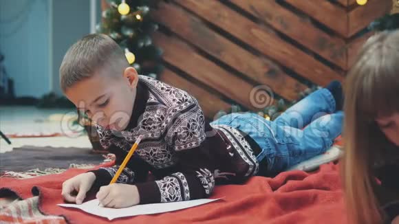 小男孩确信他一整年都表现得很好正在写信给圣诞老人以获得礼物视频的预览图
