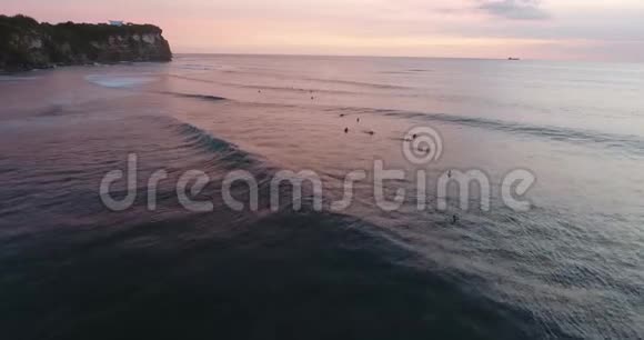 巴厘岛海滩附近的海水中有泡沫人们正在冲浪4K视频的预览图