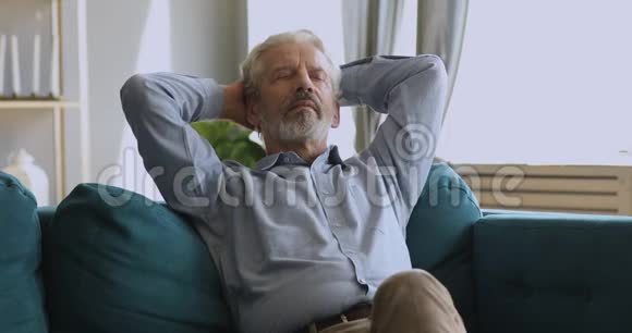 健康安详的老人在家沙发上打盹放松视频的预览图