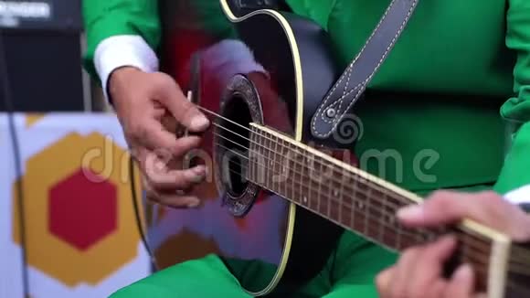 穿绿色西装的人弹黑色吉他视频的预览图