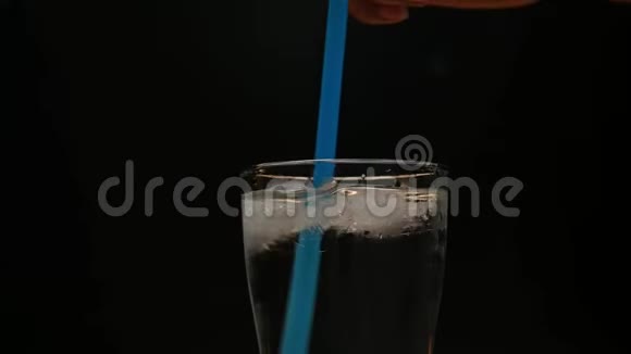 有人把冷水和冰块混合在玻璃里隔离在黑色背景上视频的预览图