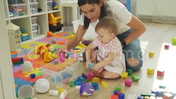 可爱的婴儿帮助她的母亲挑选玩具视频的预览图
