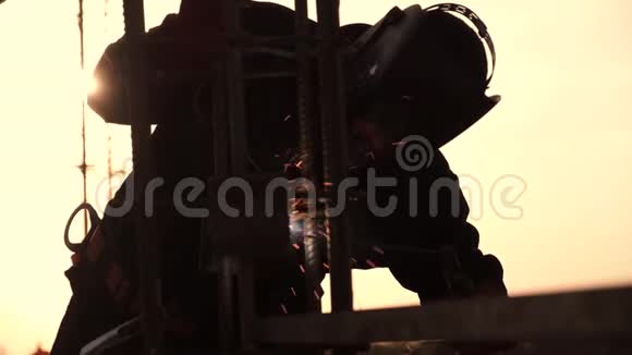 一个电焊工是在金色夕阳的背景下焊接配件视频的预览图