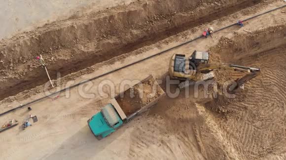 挖掘机用泥土装载卡车空中观景视频的预览图